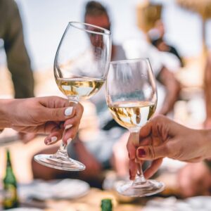 Cheers with white wine outdoors – Italian summer wine case vibes.