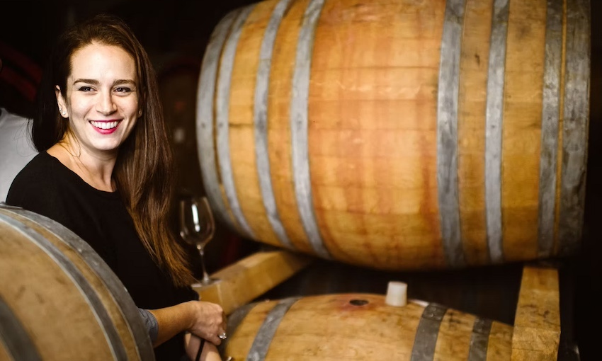 Smiling woman in a wine cellar with oak barrels – Pasetti Winery, Abruzzo