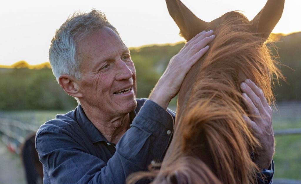 Vincenzo Abruzzese gently caressing a horse at the Valdicava estate