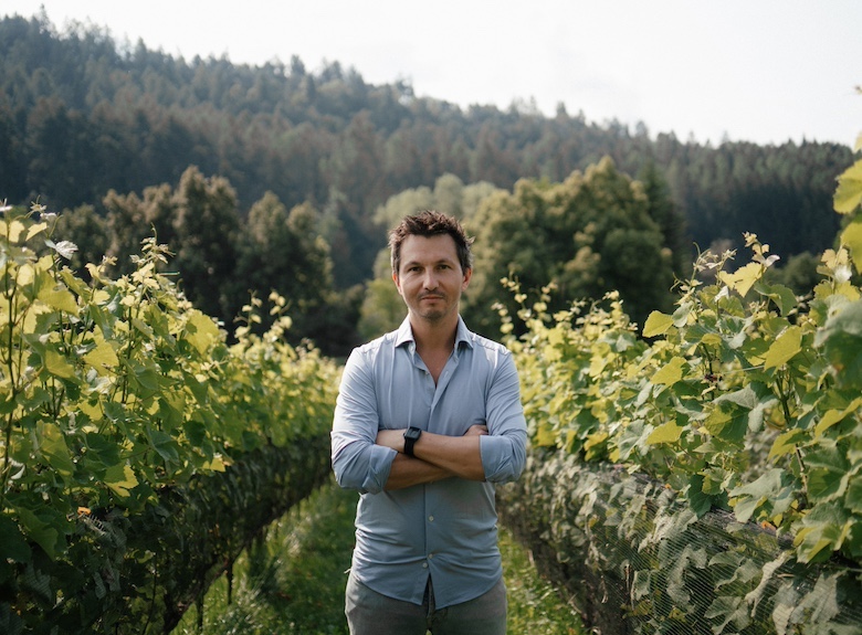 Nicola Biasi standing in a vineyard, representing the craftsmanship and innovation behind his wine.
